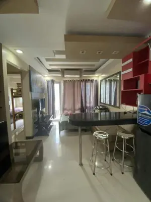 a living room with a table and two bar stools at 2br Sea Residences pool view dina in Manila