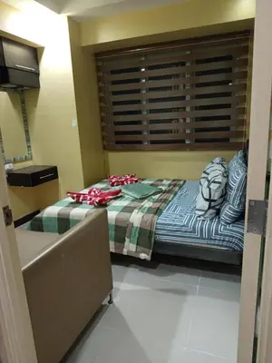 a bedroom with a large bed with a window at 2br Sea Residences pool view dina in Manila