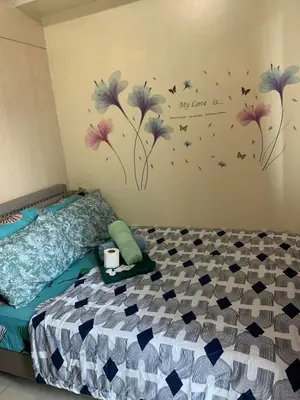 a bedroom with a bed with flowers on the wall at Sea Residences DINA in Manila