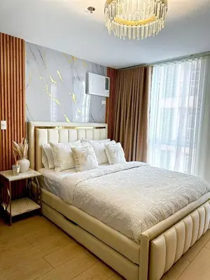 a bedroom with a large bed and a chandelier at Modern 1 bedroom spacious apartment with Venice Grand Canal View in Manila