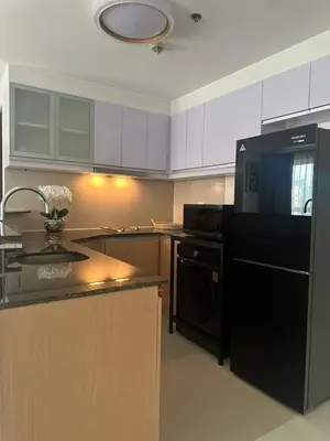 a kitchen with a black refrigerator and a sink at Modern 1 bedroom spacious apartment with Venice Grand Canal View in Manila