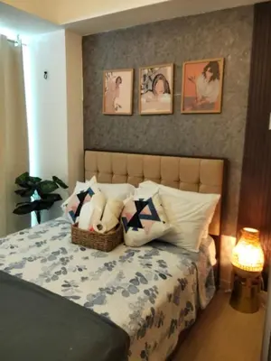 a bedroom with a bed with a bunch of pillows at OasisStaycation in Manila