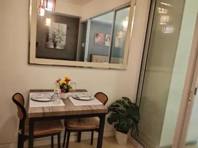 a dining room table with two chairs and a mirror at OasisStaycation in Manila