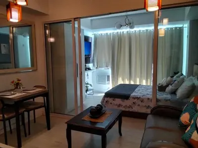 a bedroom with a bed and a living room at OasisStaycation in Manila