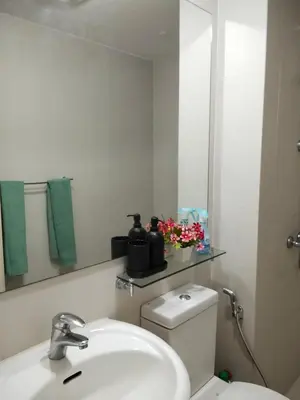 a bathroom with a toilet and a sink and a mirror at OasisStaycation in Manila
