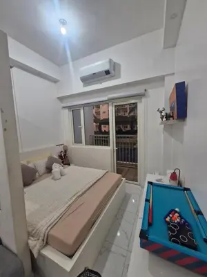 a bedroom with a large bed and a window at Wowstaycation in Manila
