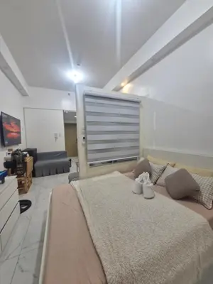 a bedroom with a large bed and a couch at Wowstaycation in Manila