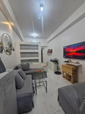 a living room with a couch and a tv at Wowstaycation in Manila