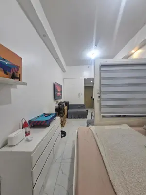 a living room with two beds and a couch at Wowstaycation in Manila