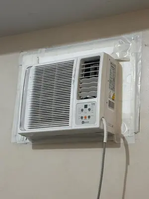 a white air conditioner hanging on a wall at Newport Inn in Manila