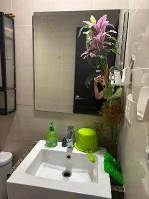 a woman taking a picture of a bathroom sink at Newport Inn in Manila
