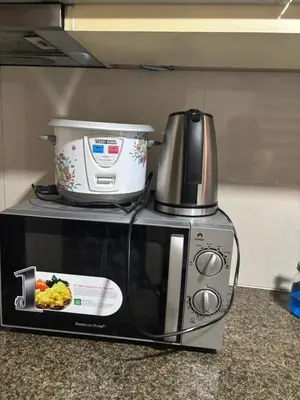 a microwave with a slow cooker on top of it at Newport Inn in Manila