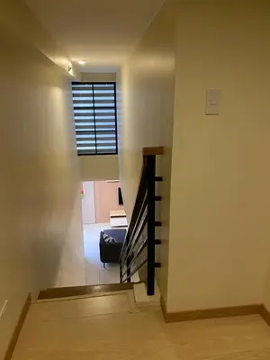 a staircase in a house with a window and a couch at EDSA Heights Unit 3422 Two br Penthouse Loft Unit AMA Tower residences in Manila