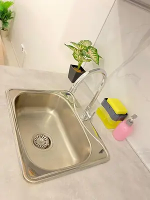 a kitchen sink with a potted plant on a counter at The Courtyard Contemporary Studio at Taguig WiFi in Manila