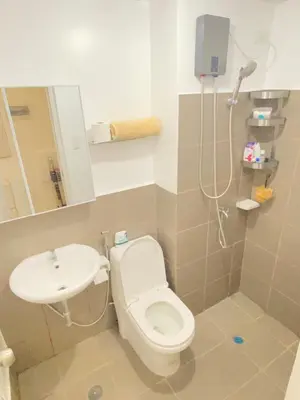 a bathroom with a toilet and a sink at The Courtyard Contemporary Studio at Taguig WiFi in Manila