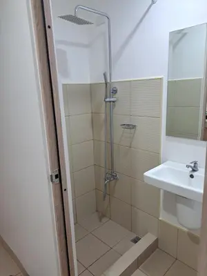 a bathroom with a shower and a sink at Ivy's CozyStaycation in Dasmariñas