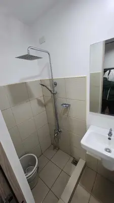 a bathroom with a shower and a toilet and a sink at Ivy's CozyStaycation in Dasmariñas