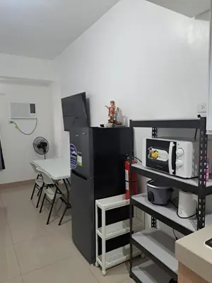a kitchen with a black refrigerator and a microwave at Ivy's CozyStaycation in Dasmariñas