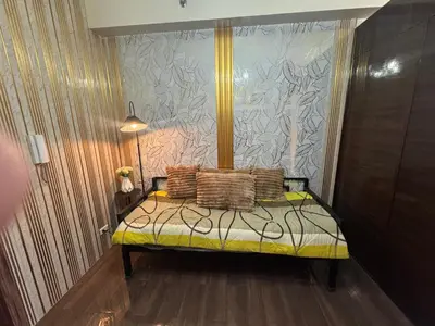 a bedroom with a bed with pillows on it at Air Residences MKT in Manila