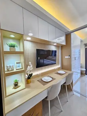 a room with a table with chairs and a television at Elegant MOA Condo at Shore Residence near the Bay in Manila