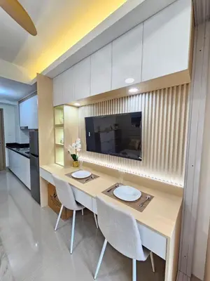 a kitchen with a large wooden table with chairs at Elegant MOA Condo at Shore Residence near the Bay in Manila