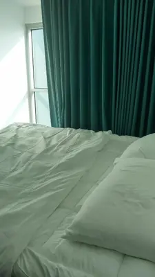 a white bed in a room with a window at Charming 1BR with Natural Light in Manila