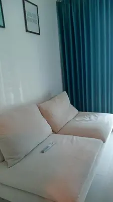 a white couch in a room with a blue curtain at Charming 1BR with Natural Light in Manila