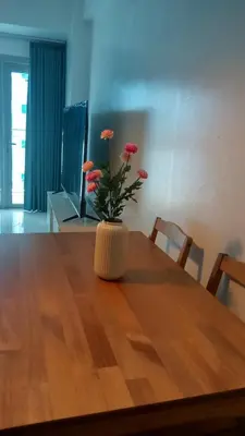 a vase with flowers sitting on top of a wooden table at Charming 1BR with Natural Light in Manila