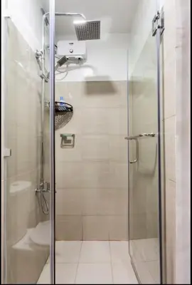 a bathroom with a glass shower with a toilet at MOA Condotel 1BR fast WiFi in Manila