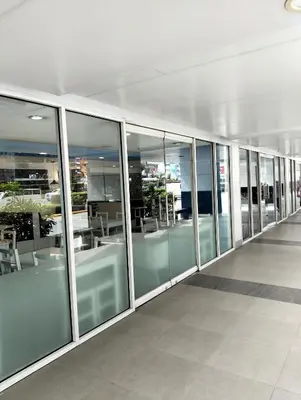 an empty hallway of an office building with glass windows at Shell Residences Mall of Asia by Jade in Manila
