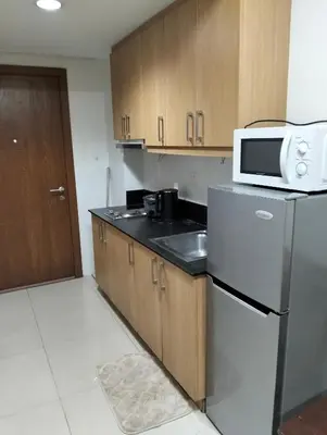 a kitchen with a stainless steel refrigerator and a microwave at Shell Residences Mall of Asia by Jade in Manila