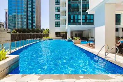 a swimming pool on top of a building at The Vibe BGC Uptown Apartment in Manila