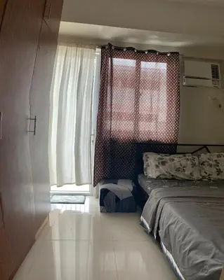 a small bedroom with a bed and a window at Cozy Apartment by Arah in Manila