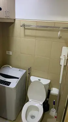 a small bathroom with a toilet and a sink at Cozy Apartment by Arah in Manila