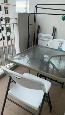 a table and a chair on a balcony at Cozy Apartment by Arah in Manila