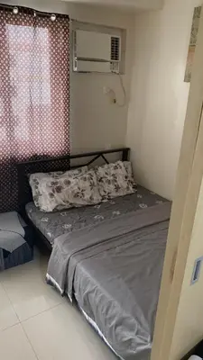 a small bedroom with a bed and a window at Cozy Apartment by Arah in Manila