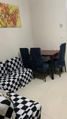 a living room with couches and a table and chairs at Cozy Apartment by Arah in Manila