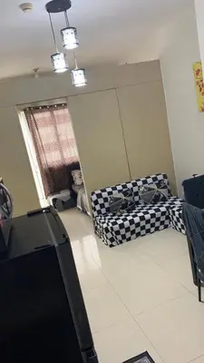 an empty room with two beds and a window at Cozy Apartment by Arah in Manila