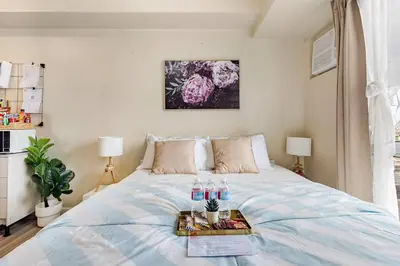 a bedroom with a bed with a tray of food on it at Studio Lune - Heart of Makati in Manila