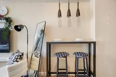 a dining room with two stools and a table at Studio Lune - Heart of Makati in Manila