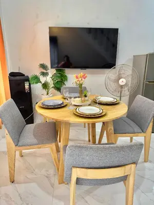a dining room table with chairs and a television at Sofias Townhouse for Rent in Dasmariñas