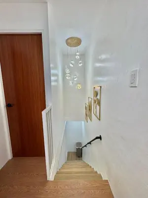 a hallway with a staircase with a chandelier at Sofias Townhouse for Rent in Dasmariñas