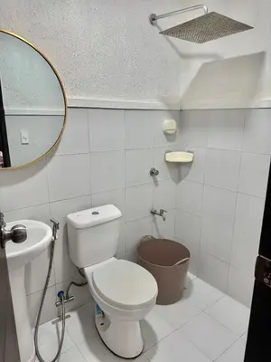 a bathroom with a toilet and a sink and a mirror at Sofias Townhouse for Rent in Dasmariñas