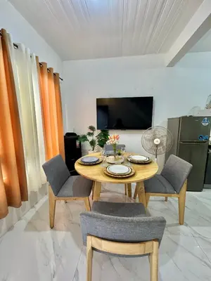 a dining room with a wooden table and chairs at Sofias Townhouse for Rent in Dasmariñas