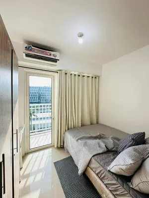 a bedroom with a bed and a large window at Shore Residences in Manila
