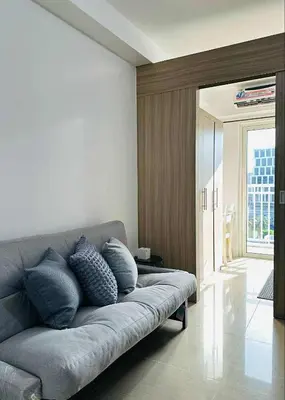 a living room with a couch with pillows on it at Shore Residences in Manila