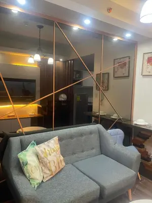 a living room with a couch and a large mirror at Maison de Joie' in Manila