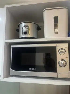 a microwave oven sitting on top of a shelf at Maison de Joie' in Manila