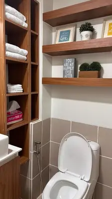 a bathroom with a toilet with wooden shelves at The Framehaus with Free Parking at Sonora Garden Residences, Las Pinas in Manila