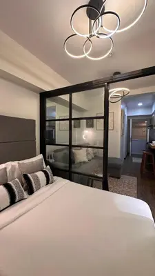 a bedroom with a large white bed and a chandelier at The Framehaus with Free Parking at Sonora Garden Residences, Las Pinas in Manila